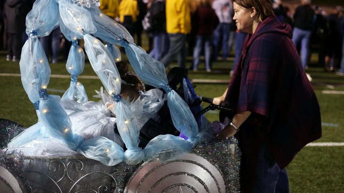 Nicole Feaster wheels her daughter, Claire Feaster, in her Cinderella carriage Sunday during the Centre Region Parks and Rec Halloween Costume Parade at Memorial Field.