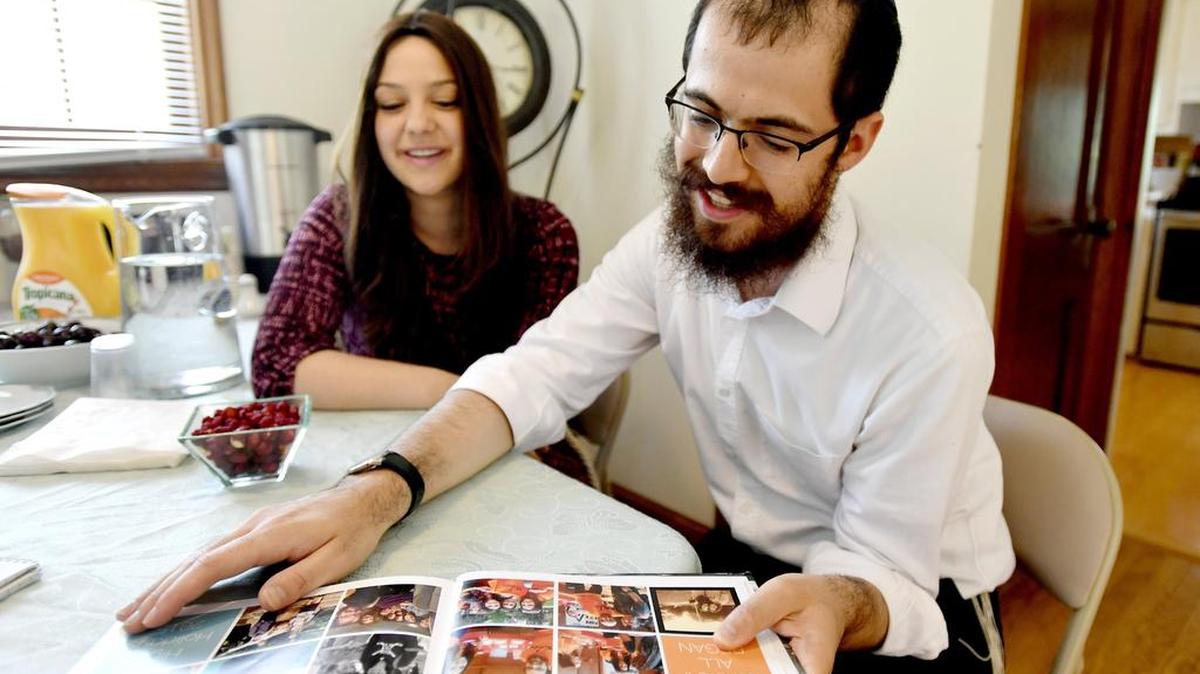 Rabbi Hershy and his wife Miri Gourarie browse photos and share stories of their first year with the PSJews in August. The Gouraries are preparing a five-course brisket community dinner at their home for after evening Rosh Hashana services this week.