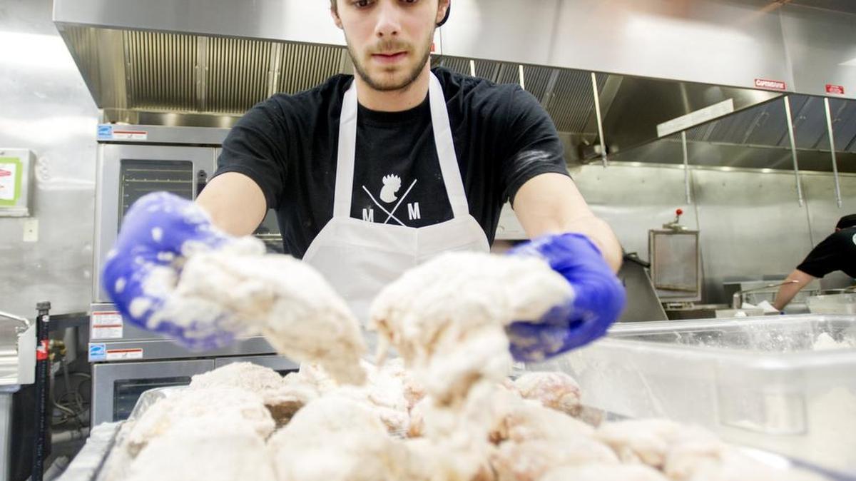 Andrew Cotter breads and prepares chicken to be fried at My My Chicken in 2016. The State College eatery, formerly takeout and delivery only, has opened its expanded space Friday, which now inludes sit-down options.