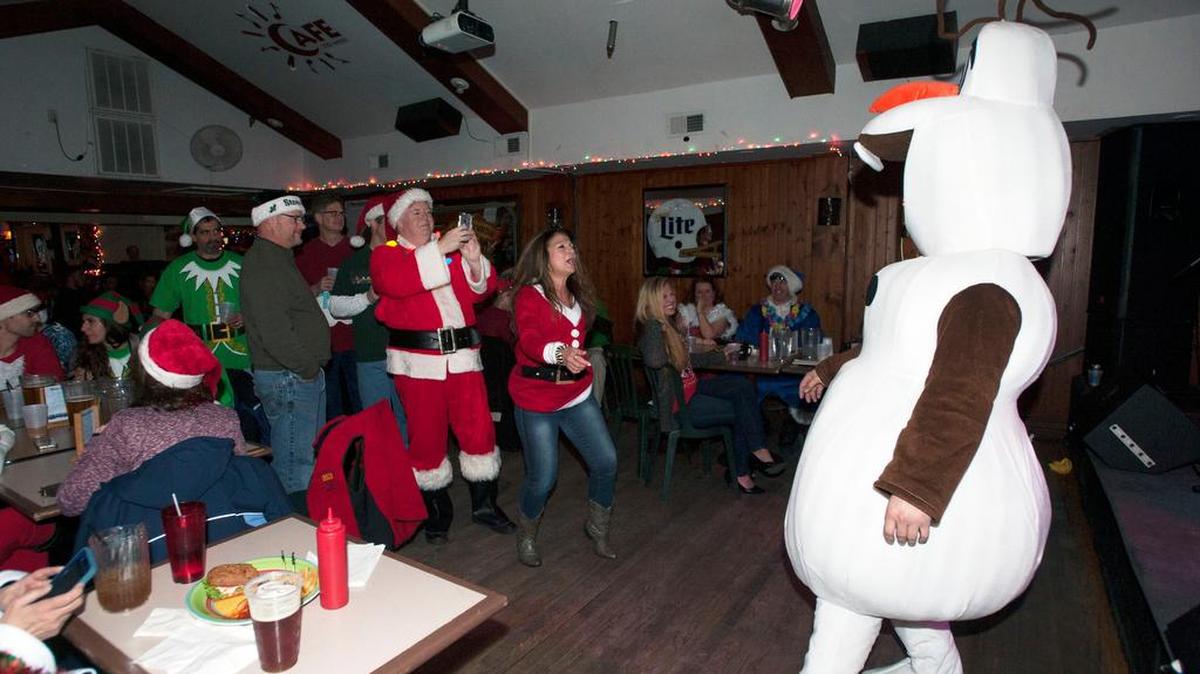 Attendees dance to live music during the Santa Crawl on Saturday at Cafe 210 West in State College.