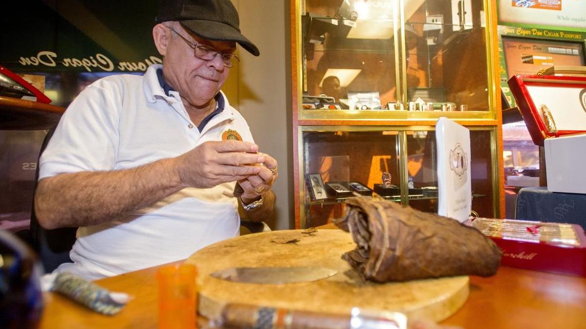 Francisco Almonte Sr., from Dominican Big Leaguer Cigars, rolls the tobacco wrapper on a cigar at Your Cigar Den on Thursday.