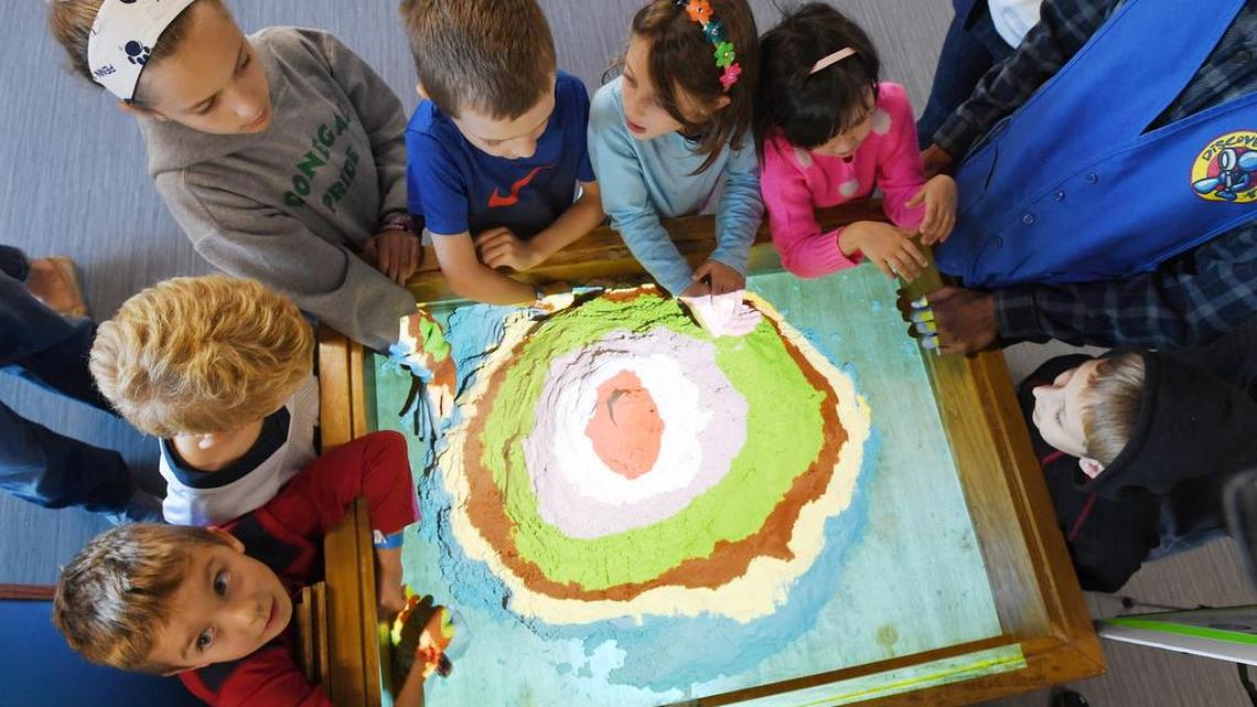 Kids play with a typographic sandbox during the opening of Discovery Space’s new location Sunday on North Atherton Street.