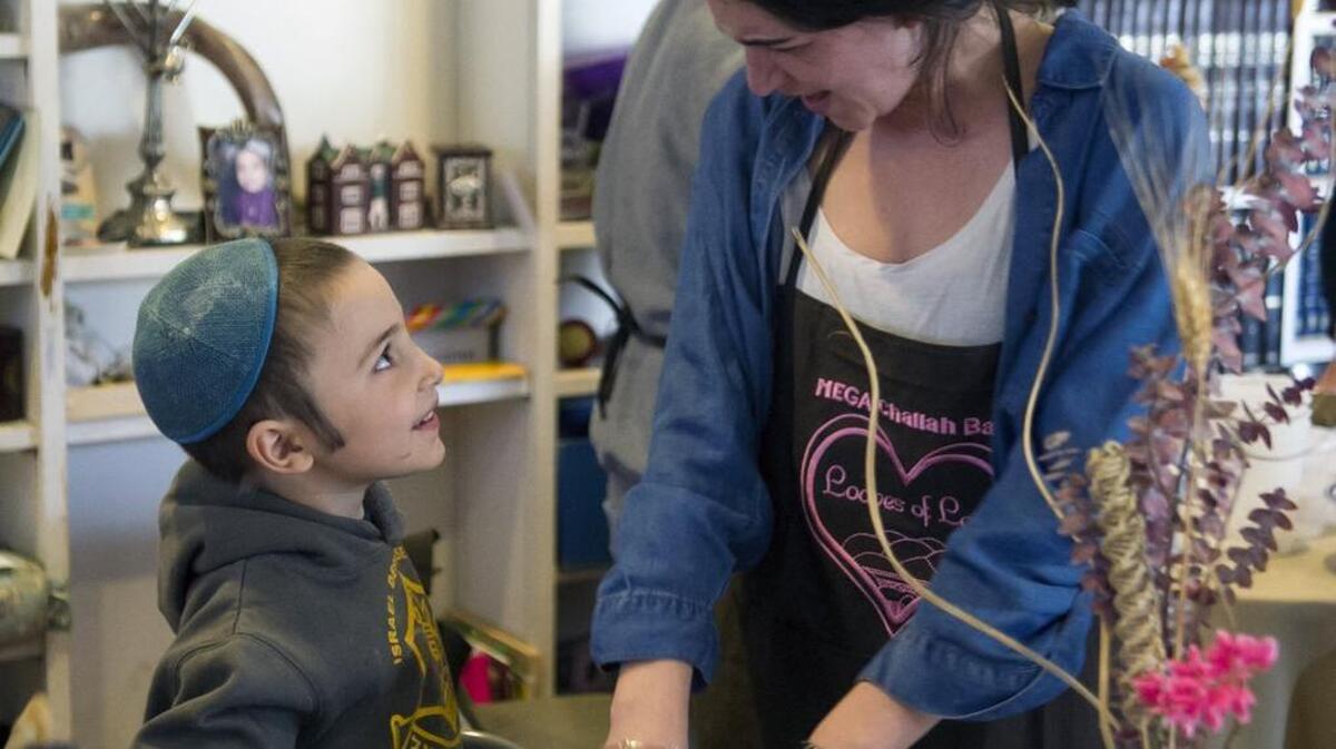 Sarah Dubrow, right, of Bucks County, mixes challah dough with Chaim Meretsky, 5, during the Mega Challah Bake at the Rohr Chabad Jewish Center on Sunday in State College. Dubrow is a Penn State student and member of Alpha Sigma Alpha and attended the event with other members of her sorority.