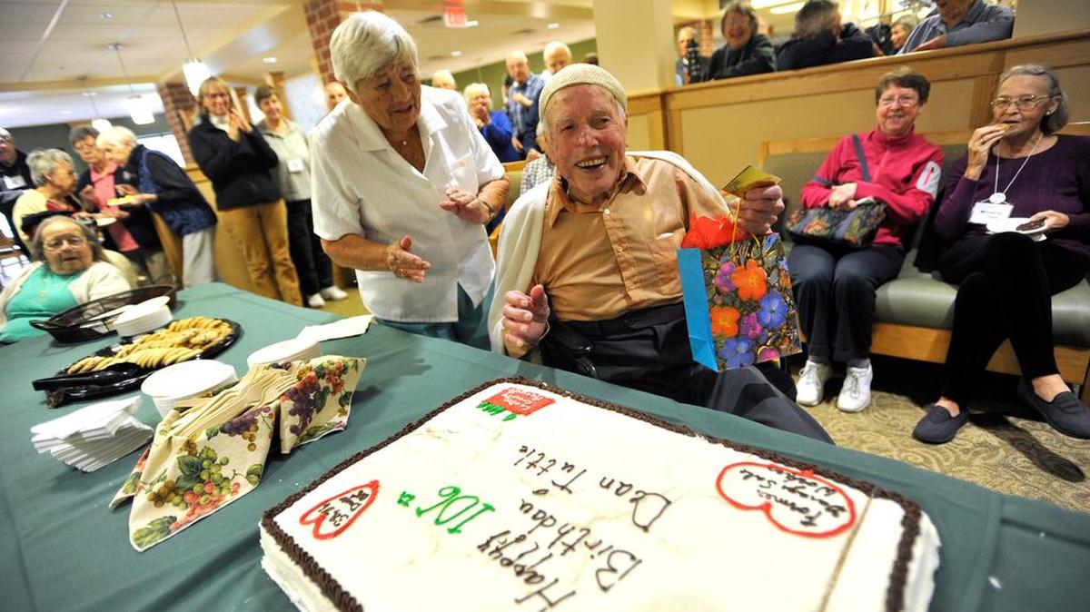 Dean Tuttle reacts as he sees his birthday cake during his party. Tuttle celebrated his 106th birthday Wednesday at Foxdale Village in State College.