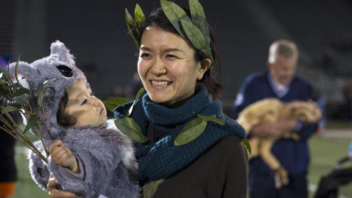 Rieko Tsusaka holds Jin Kim during the Centre Region Parks and Rec Halloween Costume Parade Sunday at Memorial Field in State College.