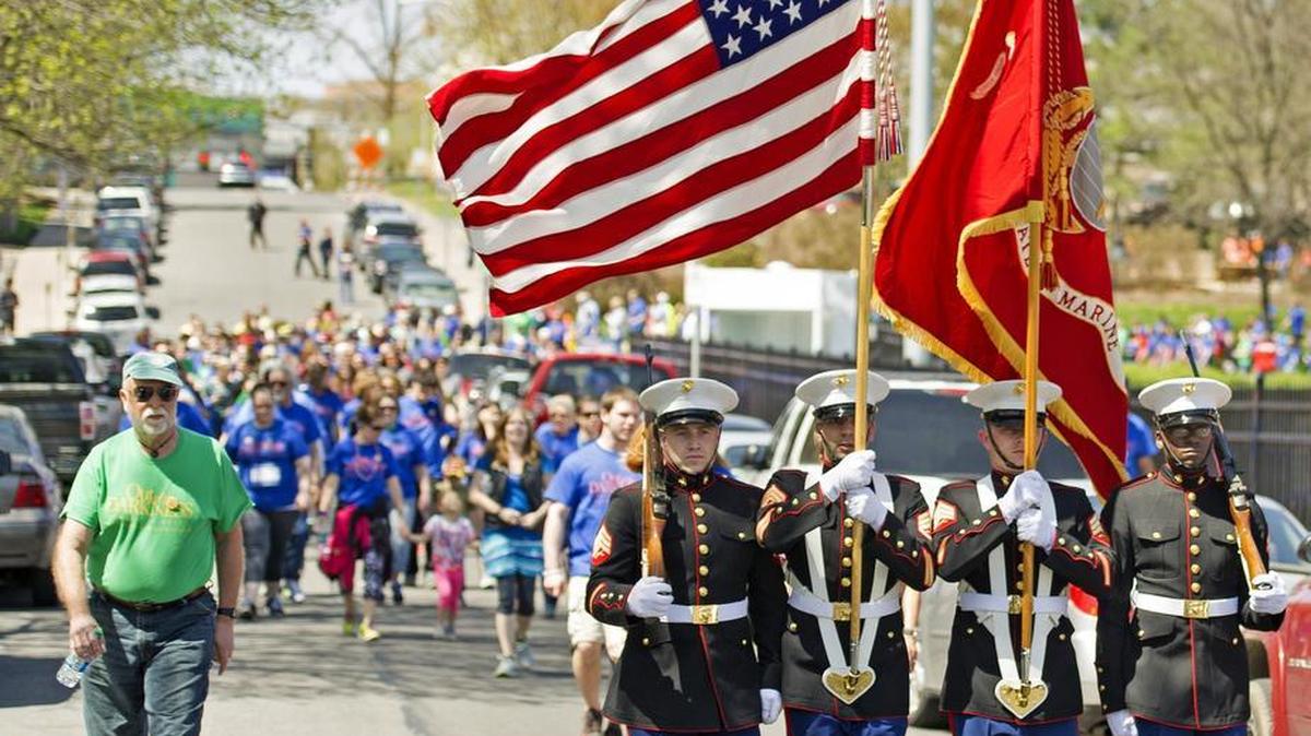 The Color Guard leads Out of the Darkness walkers up Fraser Street from Sidney Friedman Park on Sunday in State College.