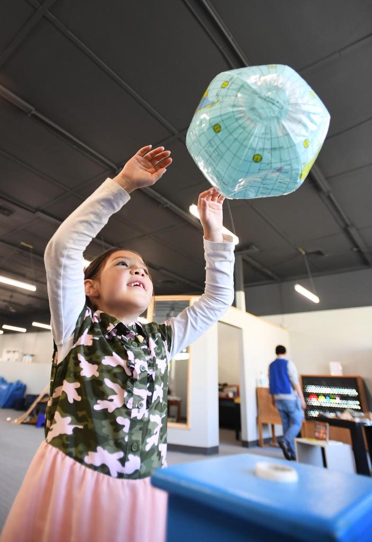 Amy Smith, 8, plays with a globe during the opening of Discovery Space at North Atherton Street.
