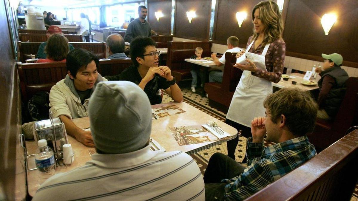 Jennifer Kane, volunteering as a waitress for a Housing Transistions fundraiser, takes orders from a table during a Thanksgiving dinner at Ye Old College Diner in 2009.