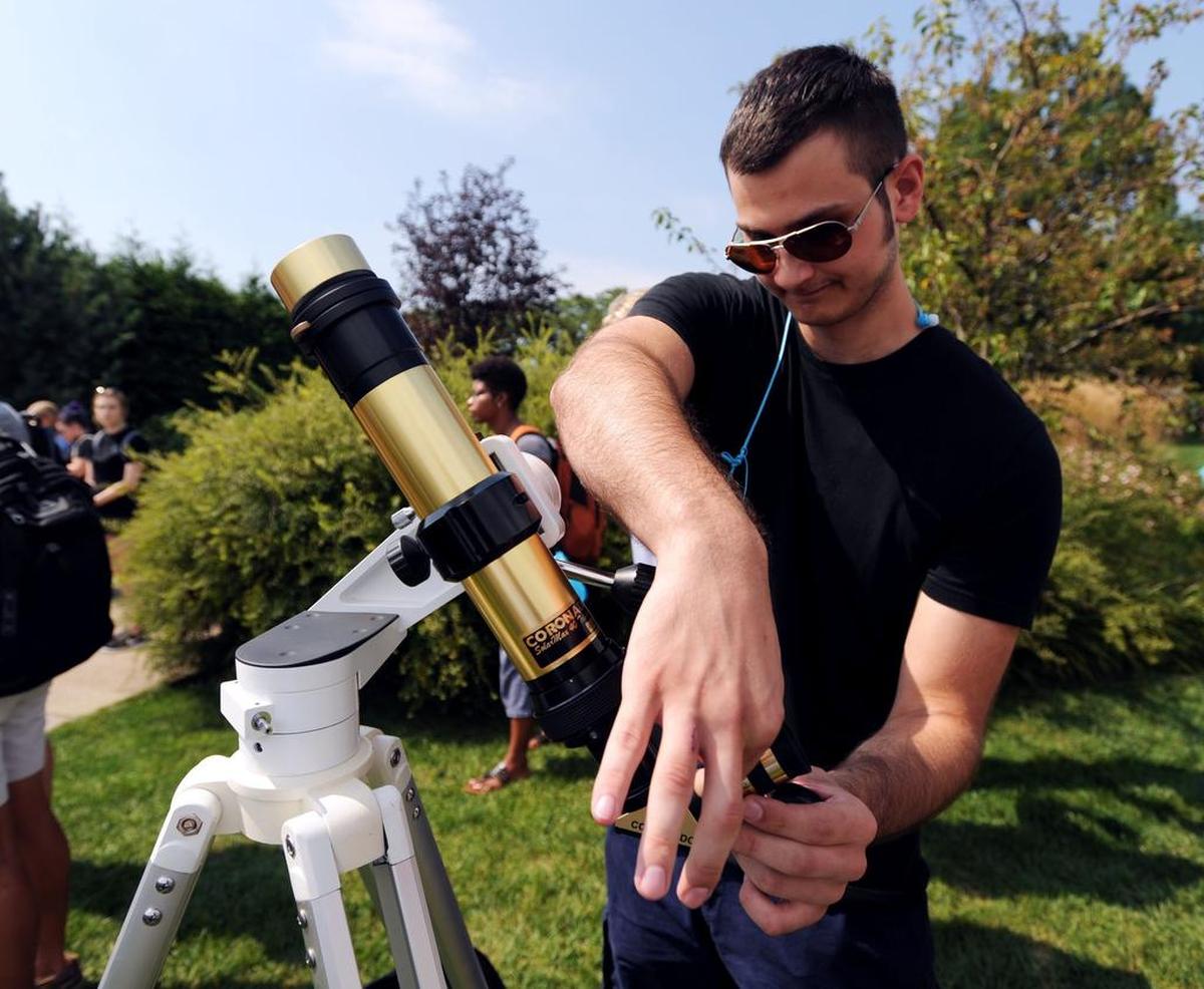 Alex Zerphy changes the eyepiece on a telescope Monday, Aug. 21, 2017 at The Arboretum at Penn State.