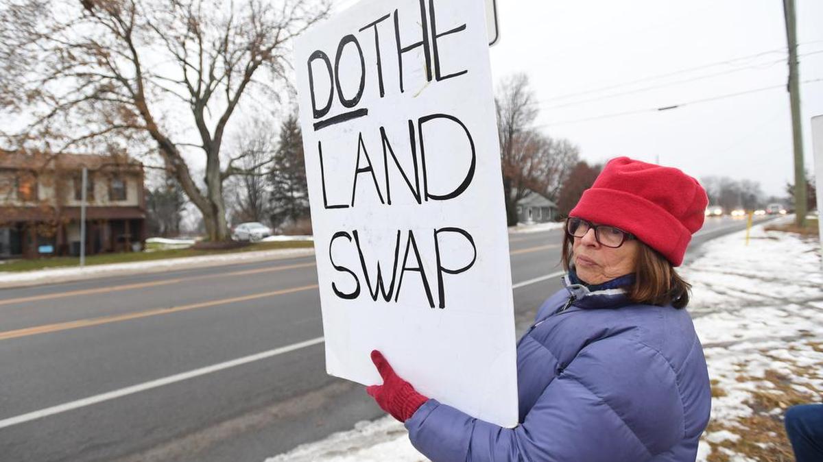 Dorothy Blair holds up a sign Monday at the proposed Toll Brothers site in Ferguson Township.
