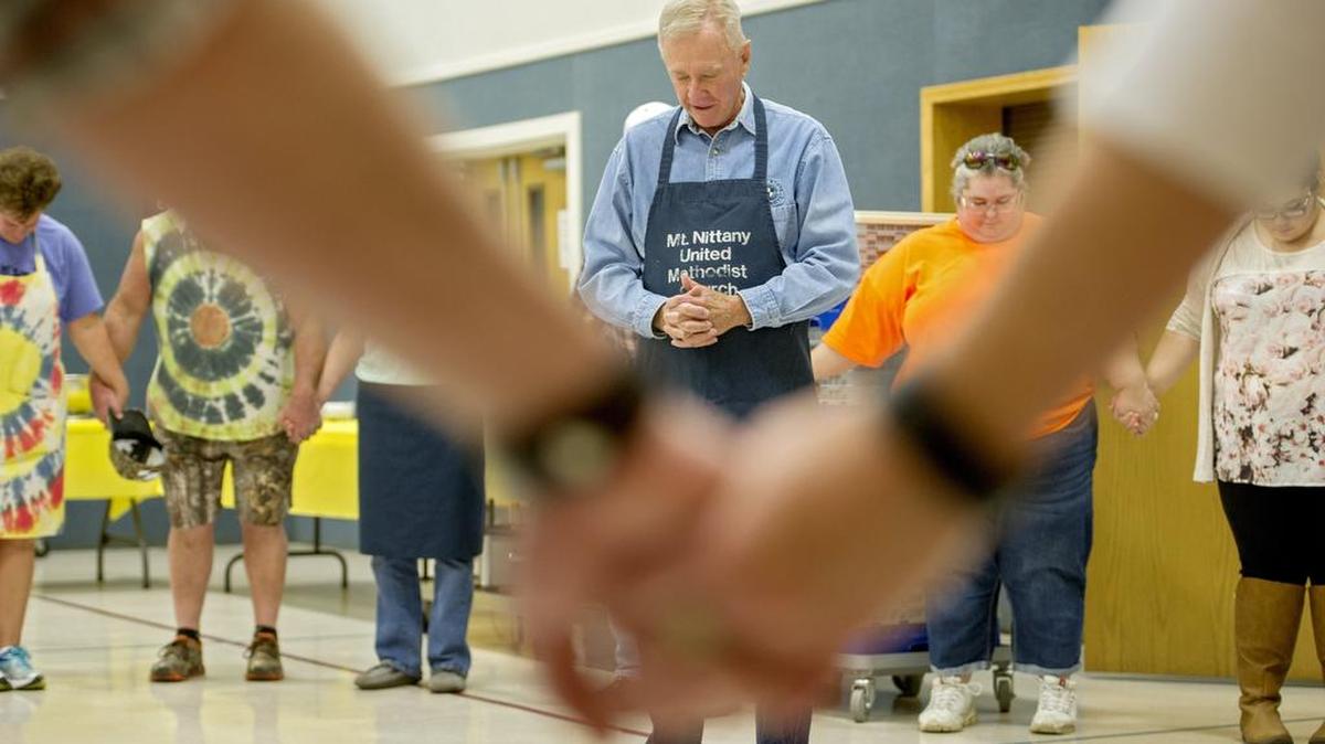 Bill Voigt shares a prayer of thanks as the volunteers all join hands at the Mt. Nittany United Methodist Church free Thanksgiving meal on Thursday. The church cooked 400 pounds of turkey for their free meal at the church and available for delivery.