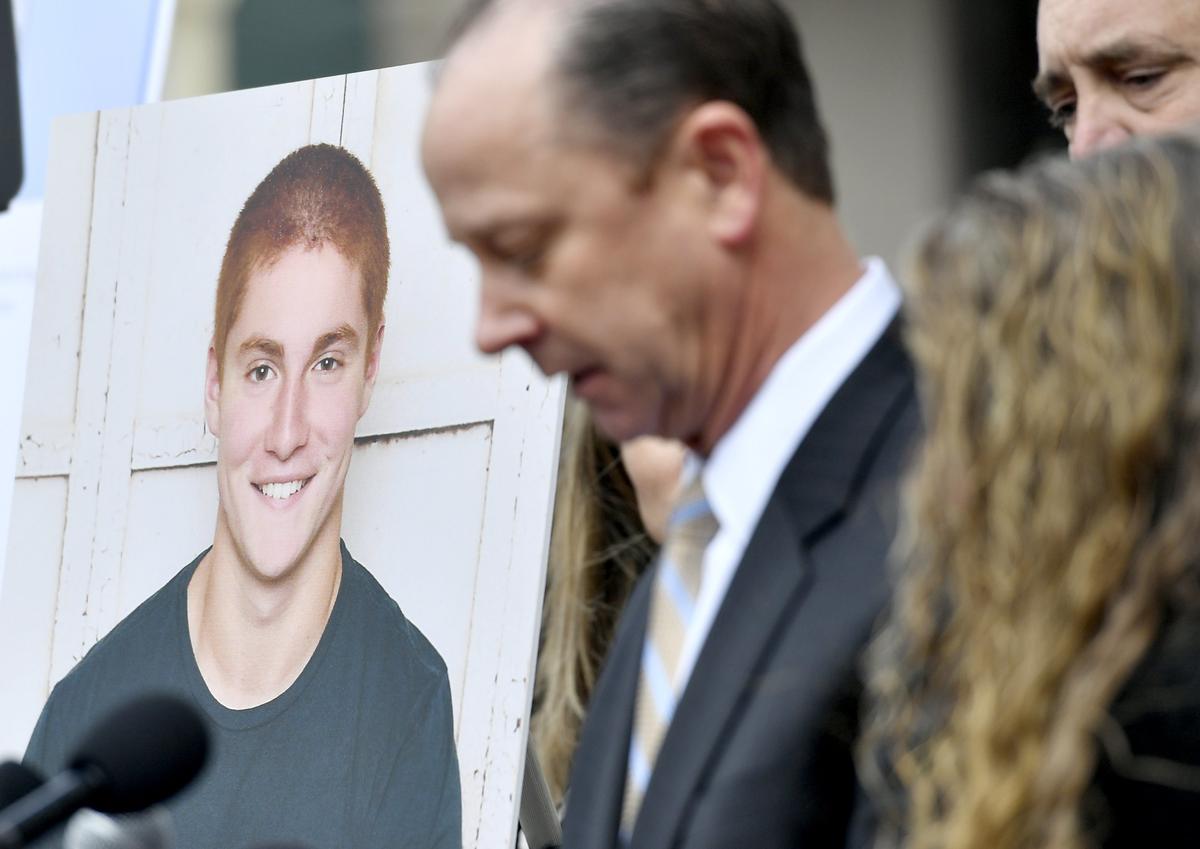 A large photo of Timothy Piazza next to his father Jim Piazza as he speaks about the importance of passing the anti-hazing legislation named after his son outside of the Centre County Courthouse on Friday, March 23, 2018.