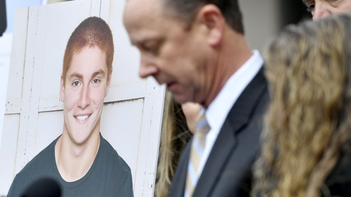 A large photo of Timothy Piazza next to his father Jim Piazza as he speaks about the importance of passing anti-hazing legislation named after his son outside of the Centre County Courthouse on Friday, March 23, 2018.