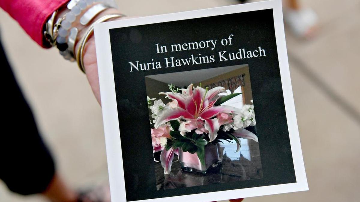 Friends show a memory book of photos of Nuria Kudlach as they wait to go into the courthouse for the trial against Alois Kudlach on Monday.
