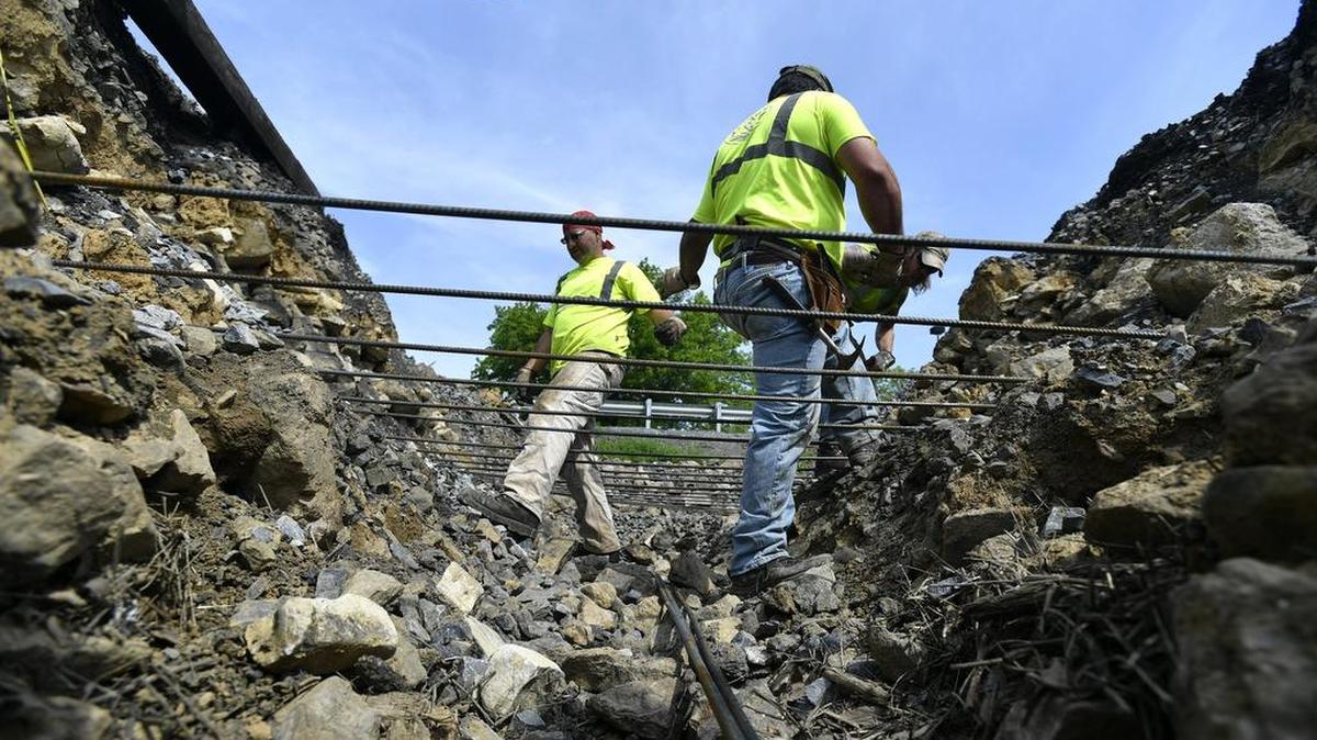 Workers fix damage to the rail line along East College Avenue in College Township on Wednesday. According to Jeb Stotter, vice president and chief operating officer of the North Shore Railroad Company, the break is the result of a sinkhole.