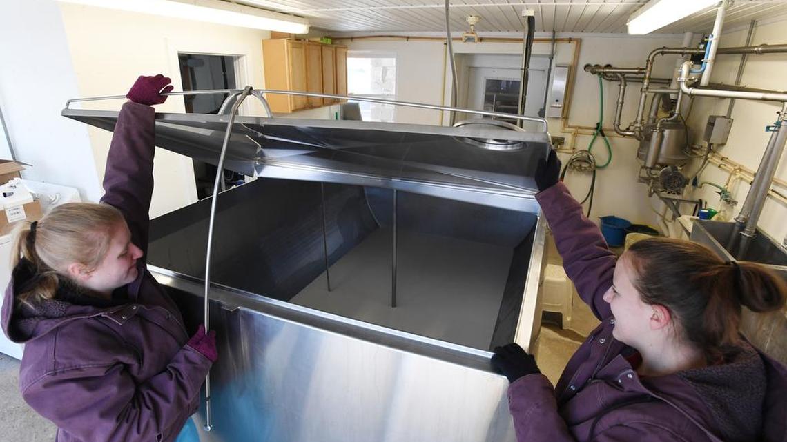 Nicole Wasson, left, and Krystal Wasson open up the bulk tank where the milk is refrigerated on Jan. 15 at Wasson Farm.