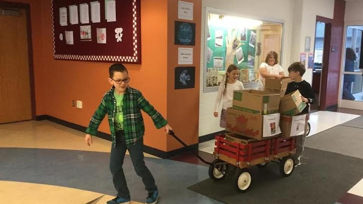Gray’s Woods Elementary School second-grade students Spencer Faust, Natalie Branstetter, Palmer Bowen and Theo Oppermann help cart donated goods collected for the food bank in Philipsburg. Erin DiPerna’s second-grade class helped spearhead the schoolwide initiative.