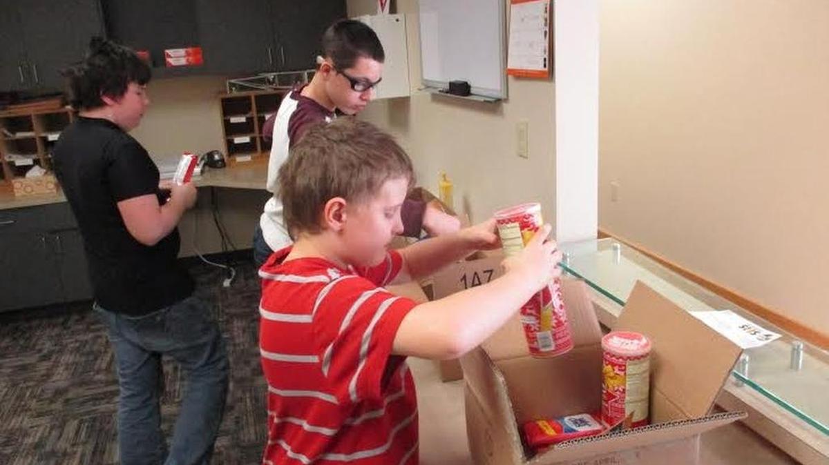 SHS students Aaron Johnson, Preston McConaughey and Anthony Lefevre put items in care packages. The care packages were sent to service members overseas.