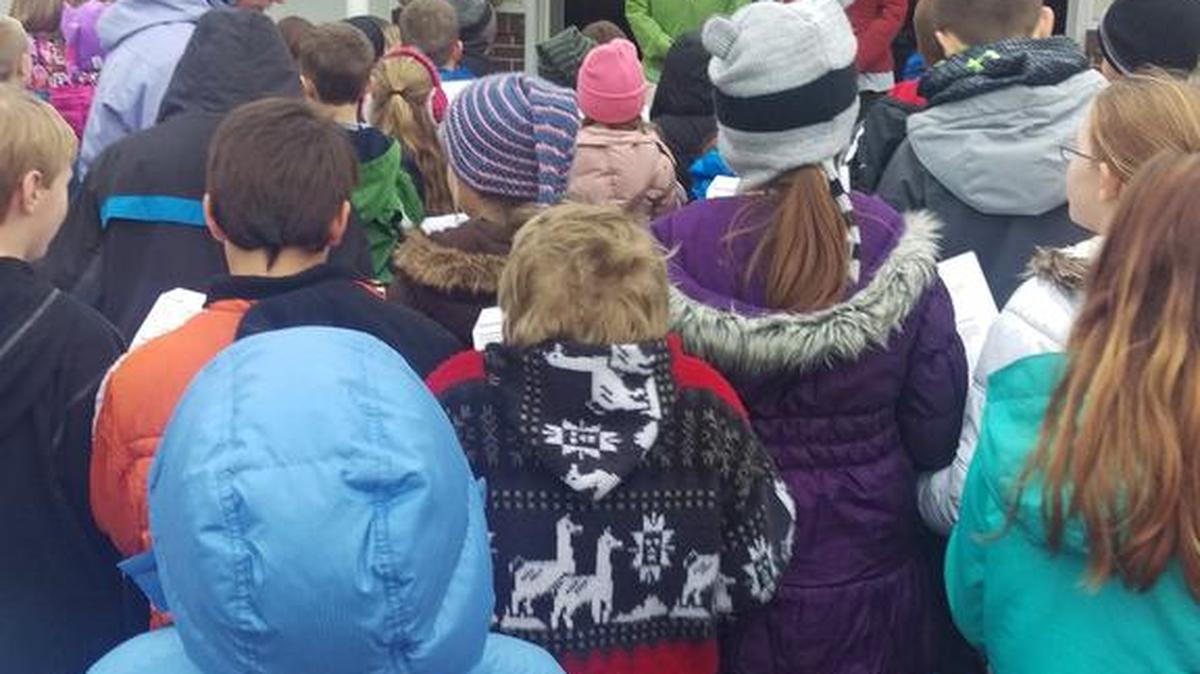 Howard Elementary students sing for retired BEA staff member Anna Confer and her neighbor.