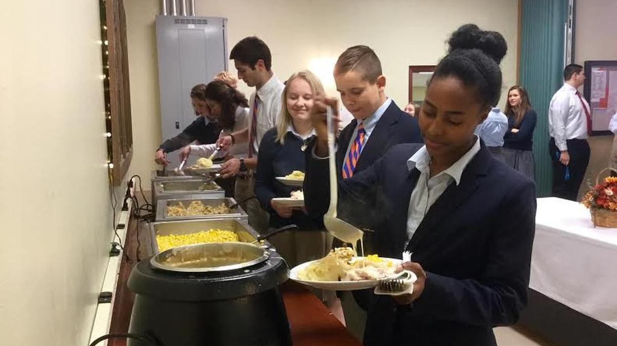 Student Addie Strauss pours gravy on her turkey and mashed potatoes. St. Joseph’s Catholic Academy held an annual Thanksgiving dinner for students and staff on Tuesday.