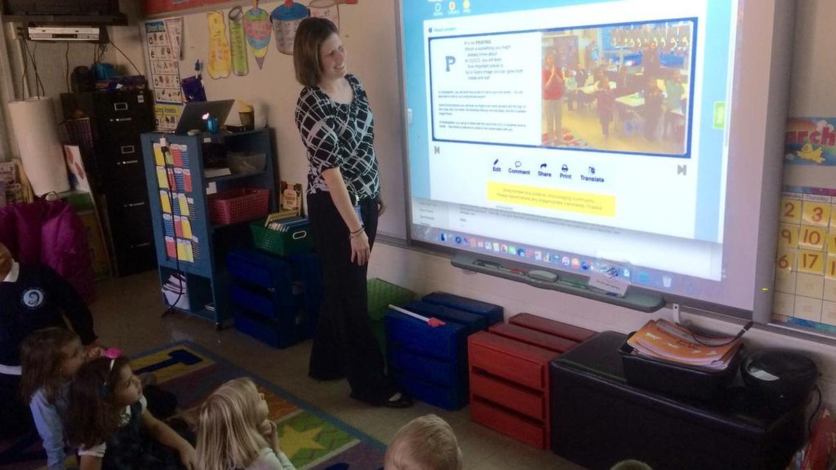 OLV kindergarten teacher Jessica Hauser shows the revised “U is for Uniform” to kindergarten students.