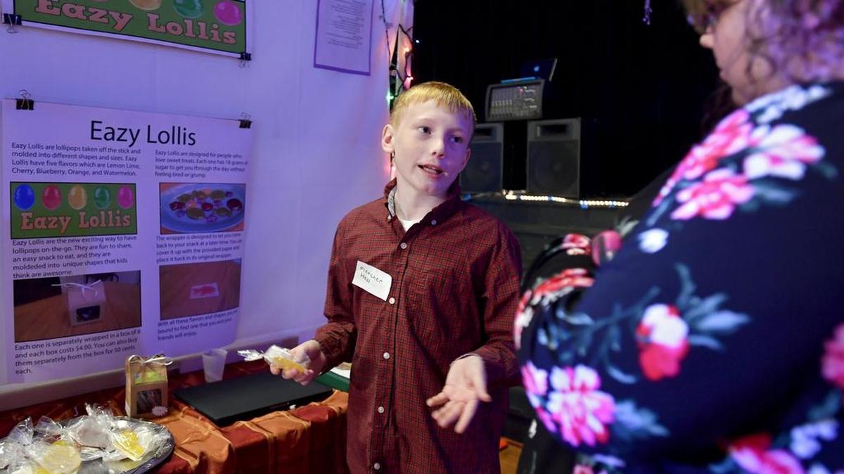Fletcher Hess talks to a visitor about his Fletch’s Lollis Eazy Lollis during the Centre Learning Community food show on Wednesday. Fletcher’s product was a lollipop without a stick that came in fun shapes and five different flavors.