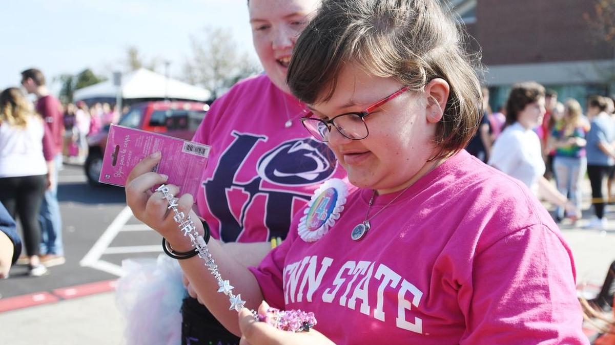 Gabrielle Chapman, 14, receives a “happy birthday” necklace during the Thon 5K Sunday at Penn State.