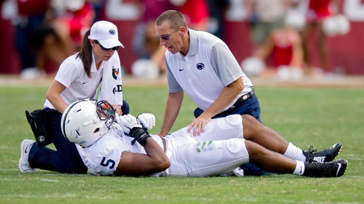 Penn State's Nyeem Wartman-White is assisted by trainer Tim Bream after going down on a play during the Saturday, September 5, 2015 game against Temple at Lincoln Financial Field.