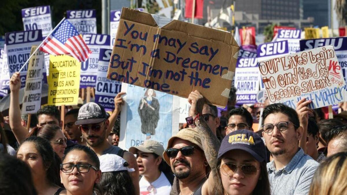 Supporters of the Deferred Action for Childhood Arrivals chant slogans and hold signs while joining a Labor Day rally in downtown Los Angeles on Monday. President Donald Trump is expected to announce this week that he will end the Deferred Action for Childhood Arrivals, but with a six-month delay, according to two people familiar with the decision-making.