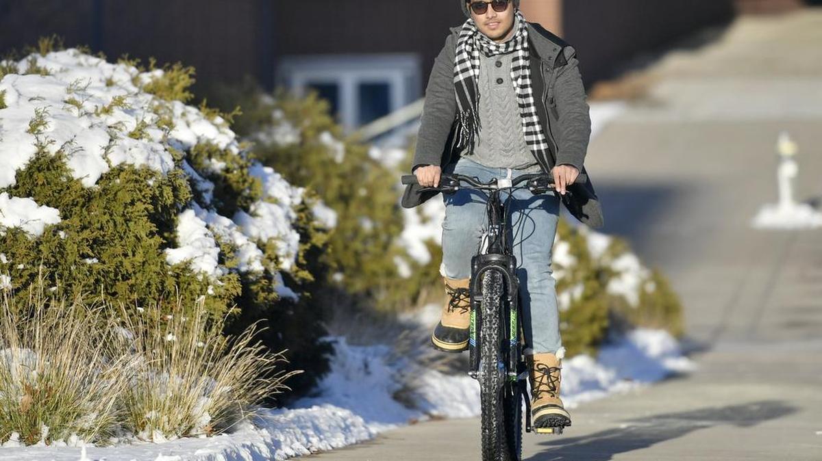 Nikhil Bharadwaj, Penn State senior majoring in energy engineering, shows the features of a bike converted to an electric bike as part of Project BYOB on Thursday.