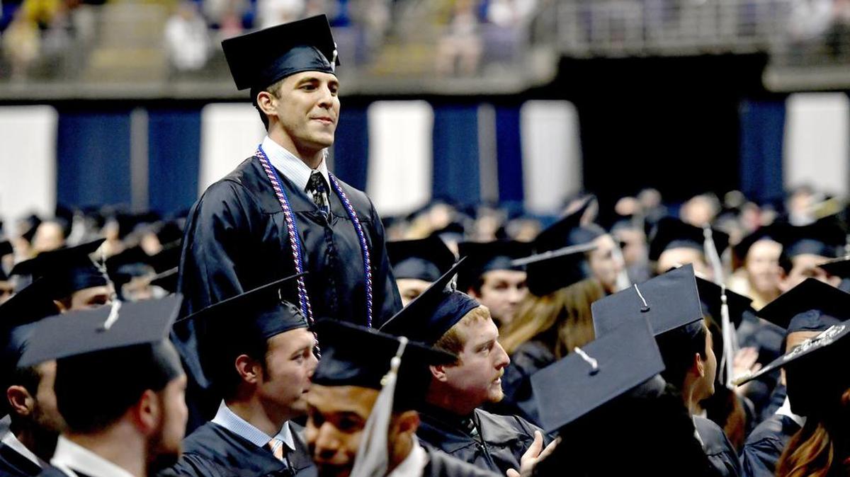 Members of the military stand to be recognized during the College of Health and Human Development commencement on Saturday. This semester’s commencements were the first to honor students who are veterans or active military with red, white and blue cords.