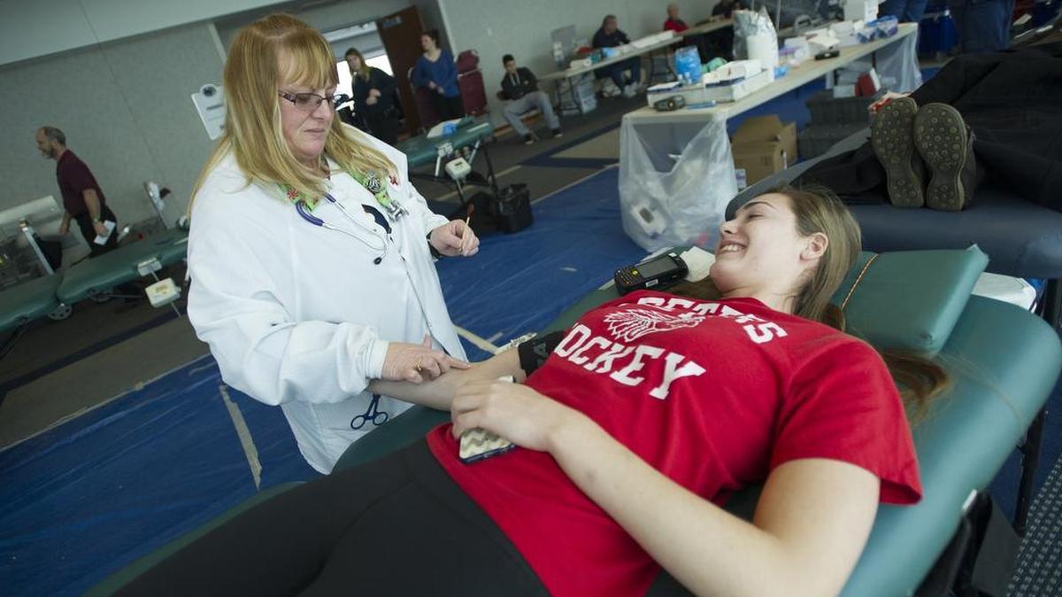 Darby Kern, a Penn State senior, prepares to donate blood while talking with collection specialist Christina Kauffman during the Bleed Blue Blood Drive at Beaver Stadium on Tuesday.