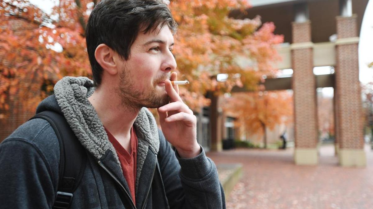 Penn State freshman Ross Dauby smokes a cigarette Monday outside the HUB-Robeson Center at Penn State. A task force commissioned by President Eric Barron last year came up with seven recommendations last month for how to make Penn State a smoke- and tobacco-free campus.