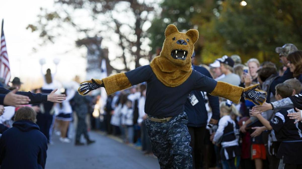 The Nittany Lion high-fives people in the crowd Saturday before the football team arrives for Penn State Military Appreciation Day at Beaver Stadium.