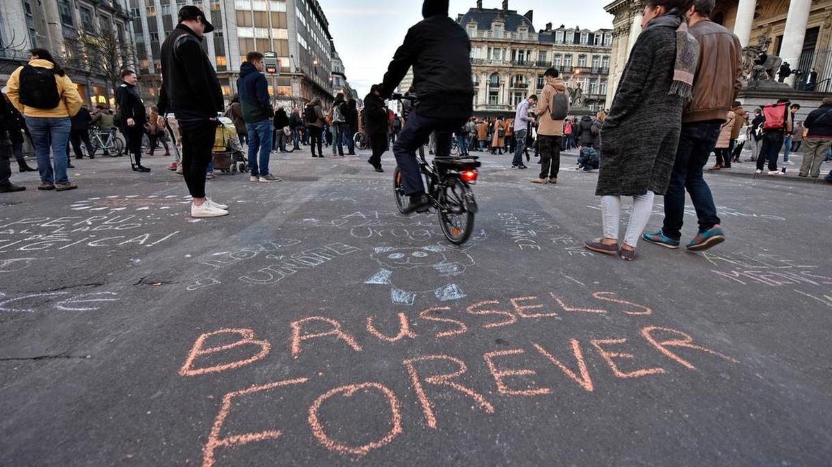 A message on the asphalt reads “Brussels Forever” at the Place de la Bourse in the center of Brussels, where people write hundreds of messages on the ground to remember the victims of the bombing attacks, Tuesday, March 22, 2016. Bombs exploded at the Brussels airport and one of the city’s metro stations Tuesday, killing and wounding scores of people, as a European capital was again locked down amid heightened security threats.