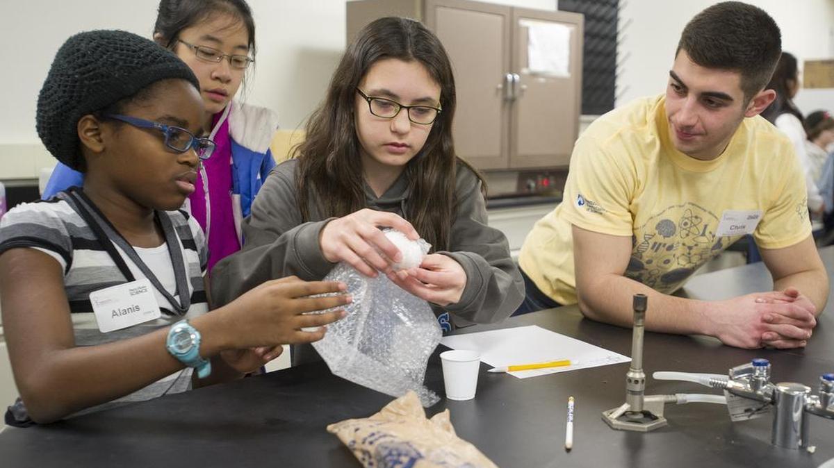From left, Alanis Walters, 11, Michelle Zhang, 12, and Rowan Ging, 13, construct an egg parachute with help from volunteer Chris Monaco, a Penn State mechanical engineering graduate student, during the Expanding Your Horizons STEMventure program in the South Frear Building on Saturday. Four teams made the parachutes out of items such as balloons, plastic bags and bubble wrap, to drop from a stairwell.