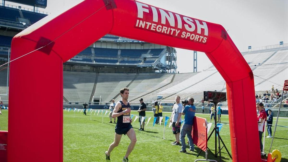 First-place winner Daniel Craighead crosses the finish line at the Paterno Family Beaver Stadium Run on Sunday at Penn State. Craighead finished the race at 15:43.43.