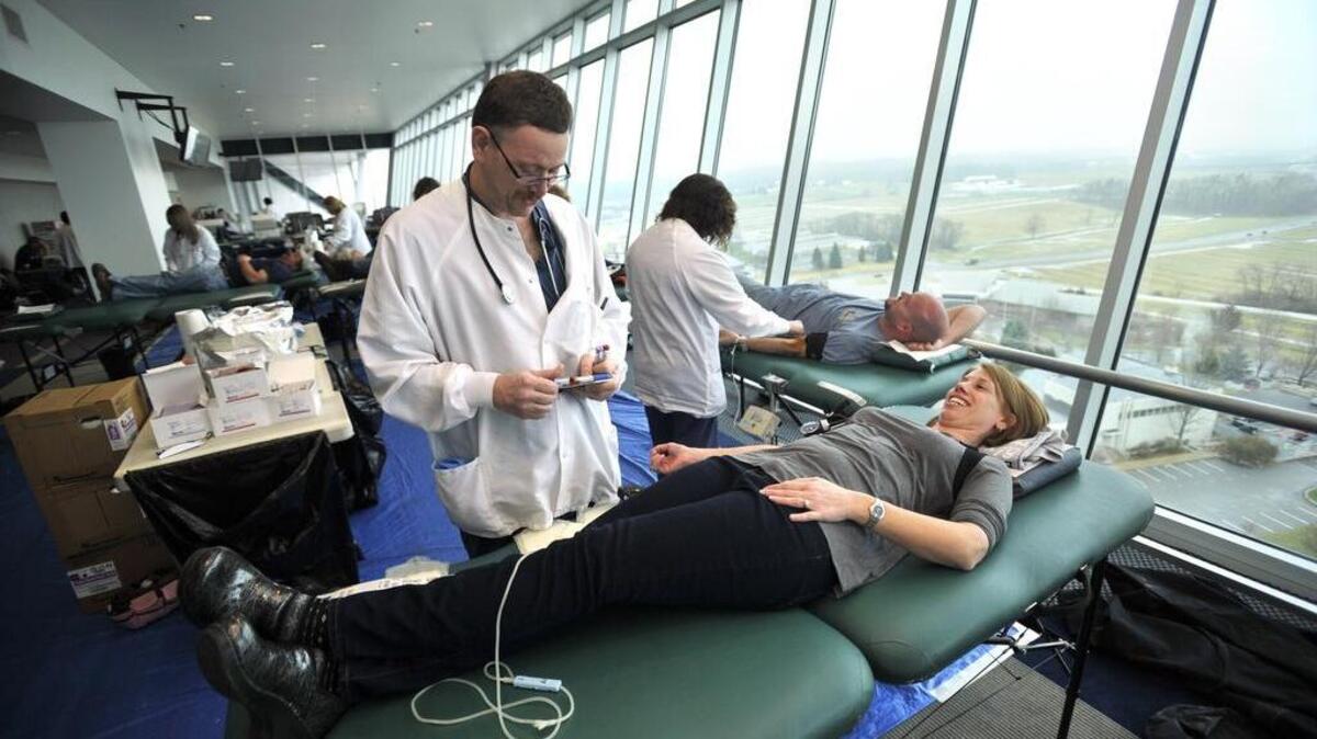 Steve Gustkey prepares to take blood from Rhondalyn Ruth in the suite during the fifth annual Beaver Stadium blood drive in 2014.