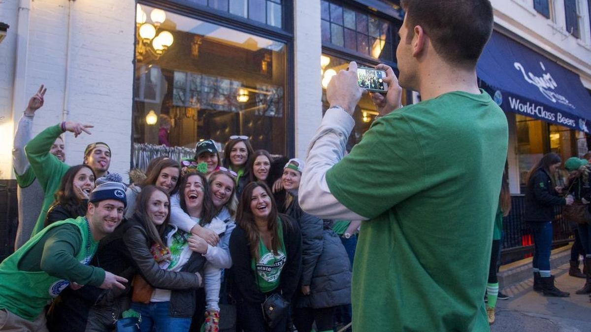 A group dressed in State Patty’s merchandise poses for a photo outside of Bill Pickle’s Tap Room in downtown State College on Saturday.