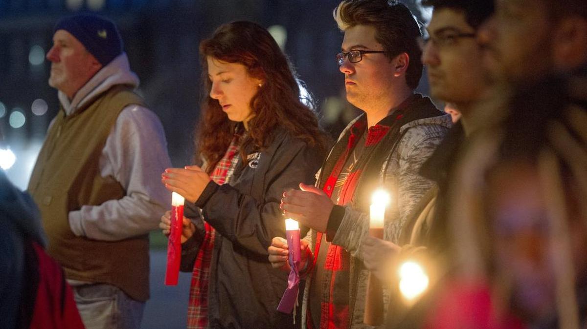 Thomas Snyder stands among Penn State students and community members for a peace vigil outside of Old Main on Tuesday, March 29, 2016.