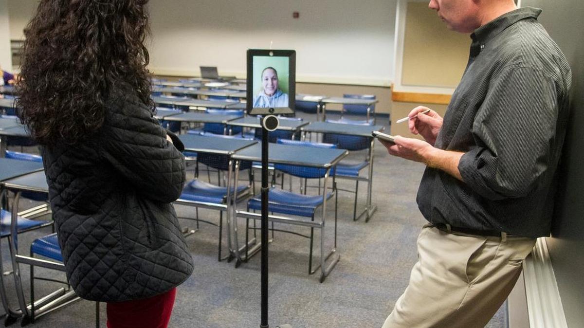 Penn State World Campus student Evonne Rivera talks with faculty advisers Cathy Hunt, left, and Brian Redmond in Rackley Building on Tuesday at Penn State via an iPad connected to “Sheldon,” a robot created by Double Robotics. Rivera remotely joined the Psi Chi chapter meeting from Pasadena, Calif. Rivera is the chapter president of the World Campus Psi Chi Honor Society.