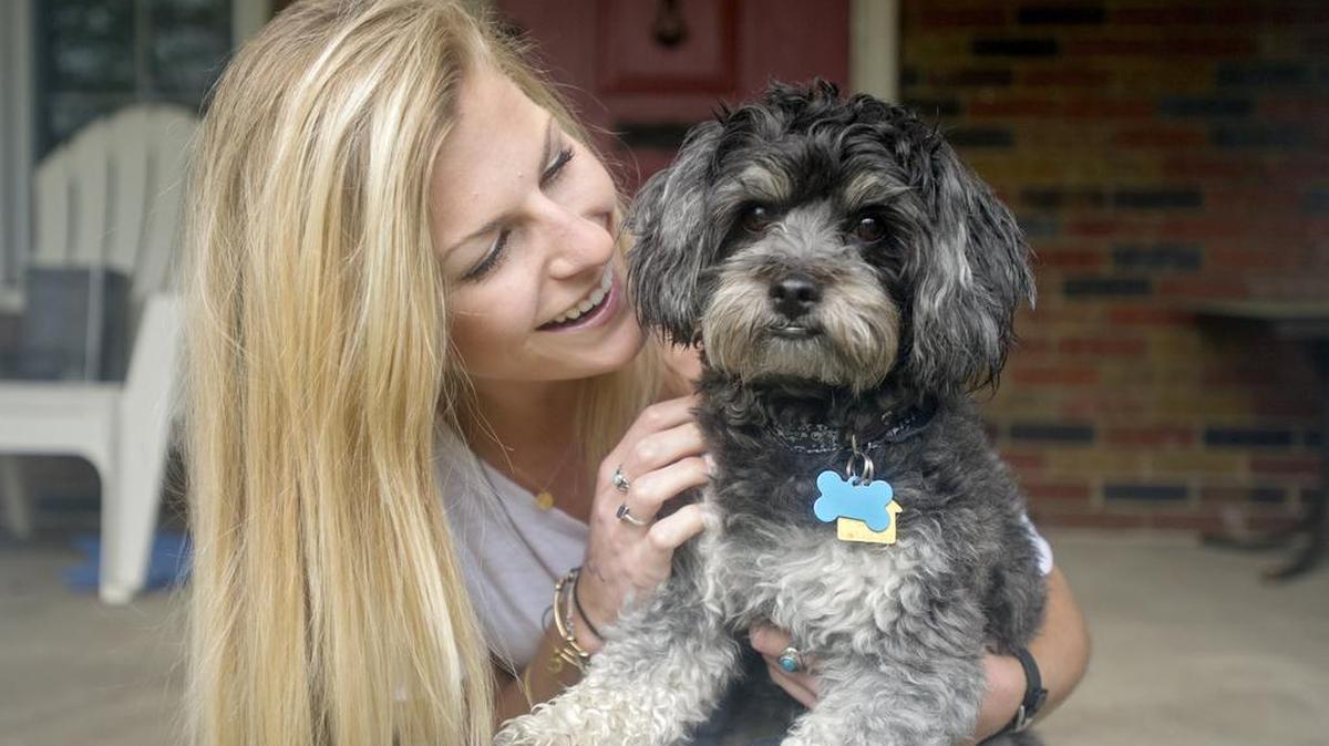 Paige Raque sits with her dog Toby outside of their apartment on Wednesday. Raque graduated from Penn State’s College of Health and Human Development on Saturday.