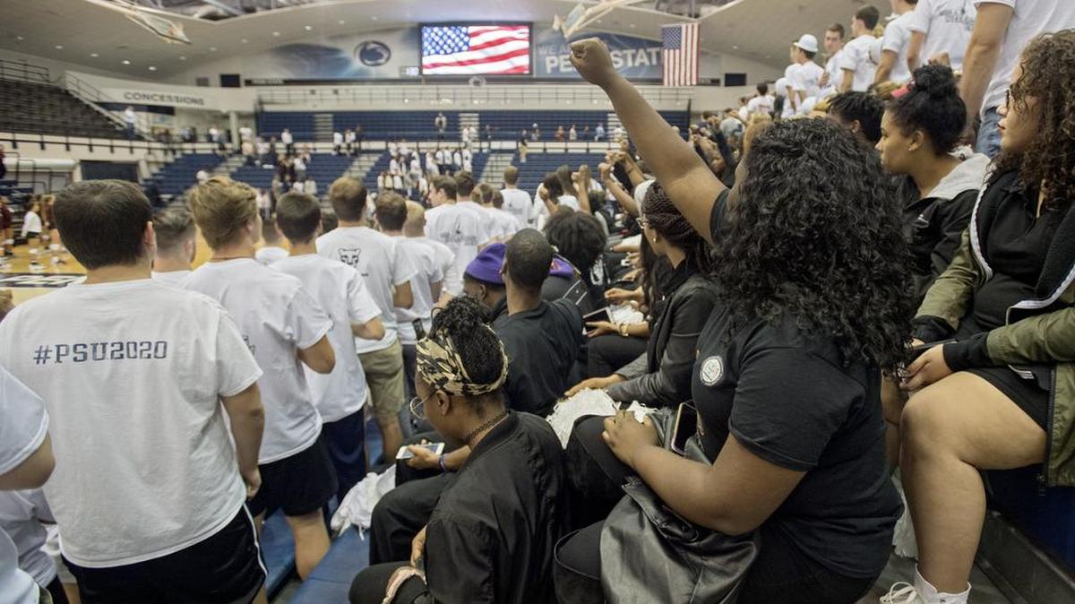Members of the Penn State chapter of NAACP sit during the national anthem before the Penn State women’s volleyball game against Minnesota on Wednesday at Rec Hall.
