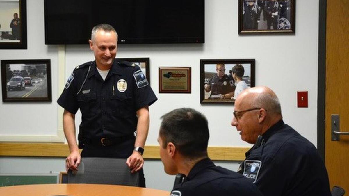 Penn State police Chief Keith Morris, standing, speaks with officers Alan Miller, left, and Jeff Jones. Morris took over as the university’s chief on April 20.