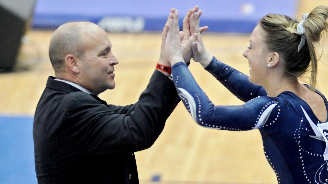 Penn State women’s gymnastics coach Jeff Thompson high fives one of his athletes after her performance on the vault during the 2014 NCAA Women’s Regional Championships in 2014 in Rec Hall.