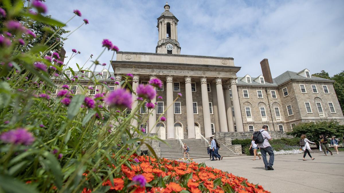 Penn State students walk by Old Main on the first day of classes on Monday, August 20, 2018.