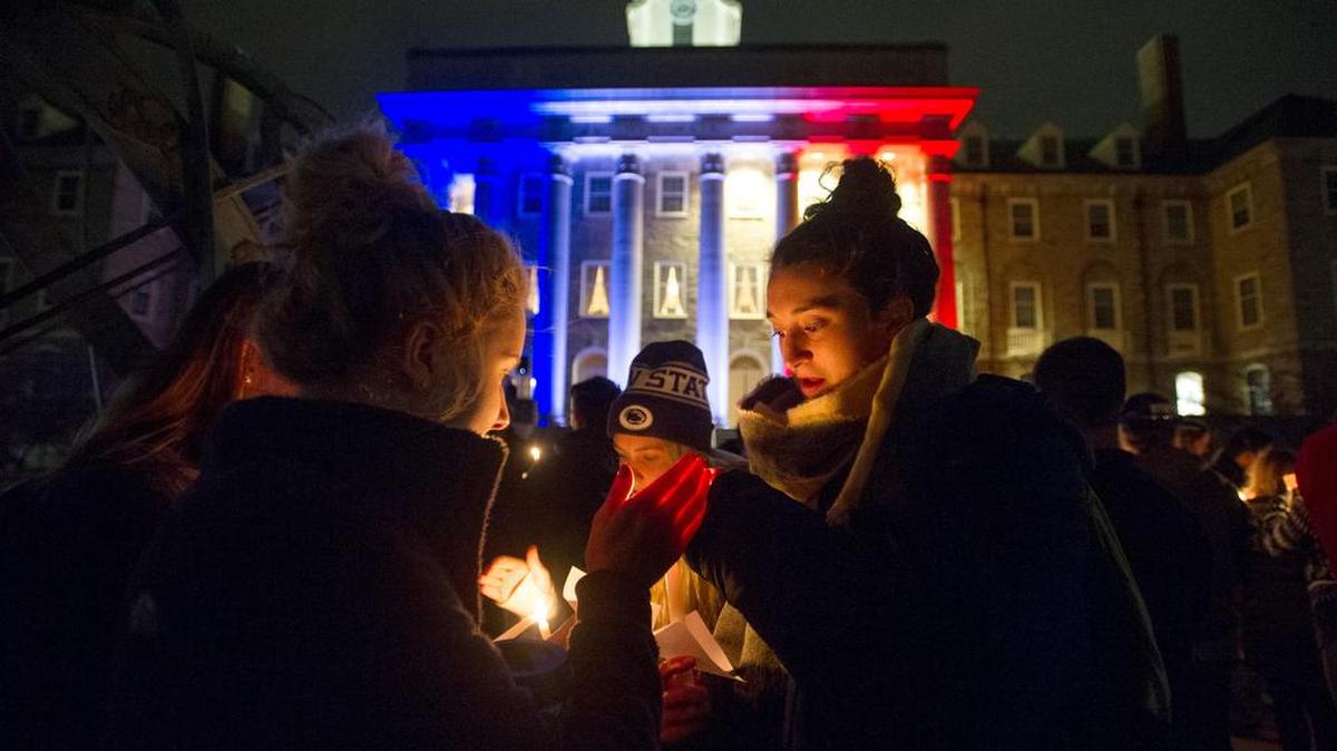 Penn State students light candles as they gather outside of Old Main on Tuesday for a vigil to honor the attacks in Paris and around the world.