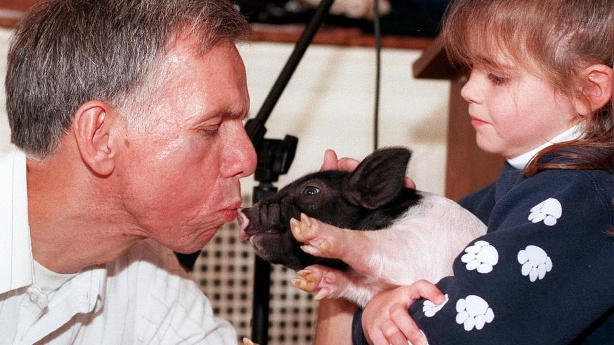 Mike "The Mailman" Herr of State College kisses "Flower" the pig, held by its owner Emilie Campbell, 4, of Pennsylvania Furnace. This was during a luncheon and auction at the Robeson Center on campus.