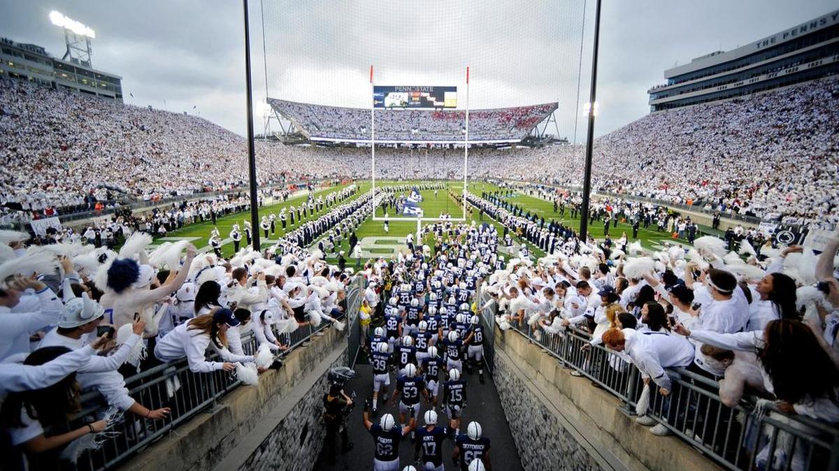 The Penn State football team runs onto the field for a 2012 game against Ohio State. Saturday’s game against Michigan will be a white out, and a portion of the ticket sales will benefit Thon.