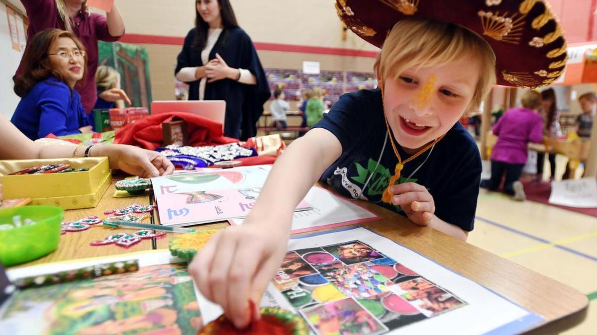 Kindergartner Xander Hawkins rubs Holi powder on his face during the “Countries Around the World” event on Friday at Marion-Walker Elementary School.